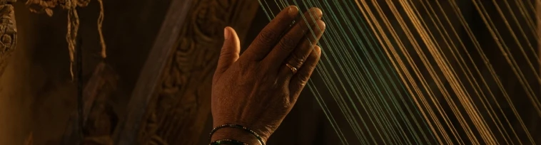 Close-up of hand threading the loom